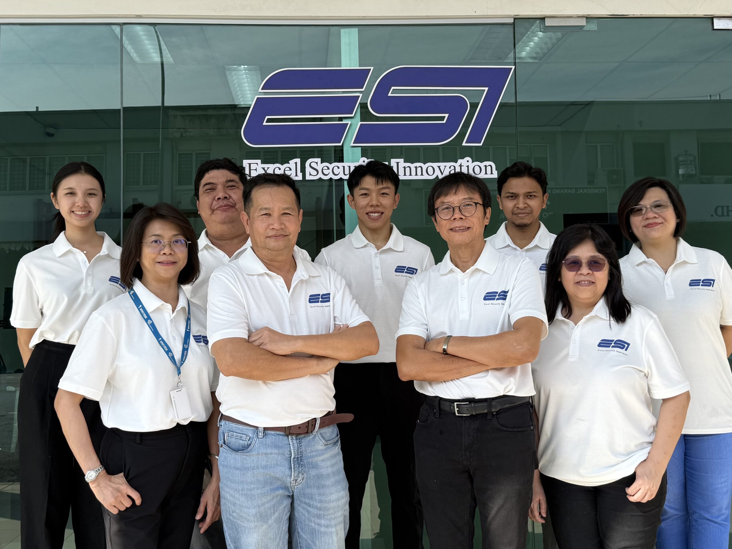 The ESI Access head office team outside the Subang Jaya office, beneath the ESI Excel Security Innovation signage