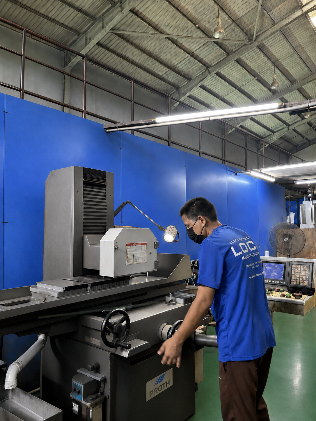 An ESI Access operator working at a surface grinding machine on the Merlimau factory floor